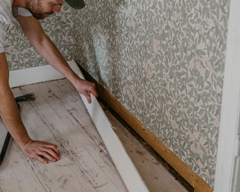 En man tar bort golvlister