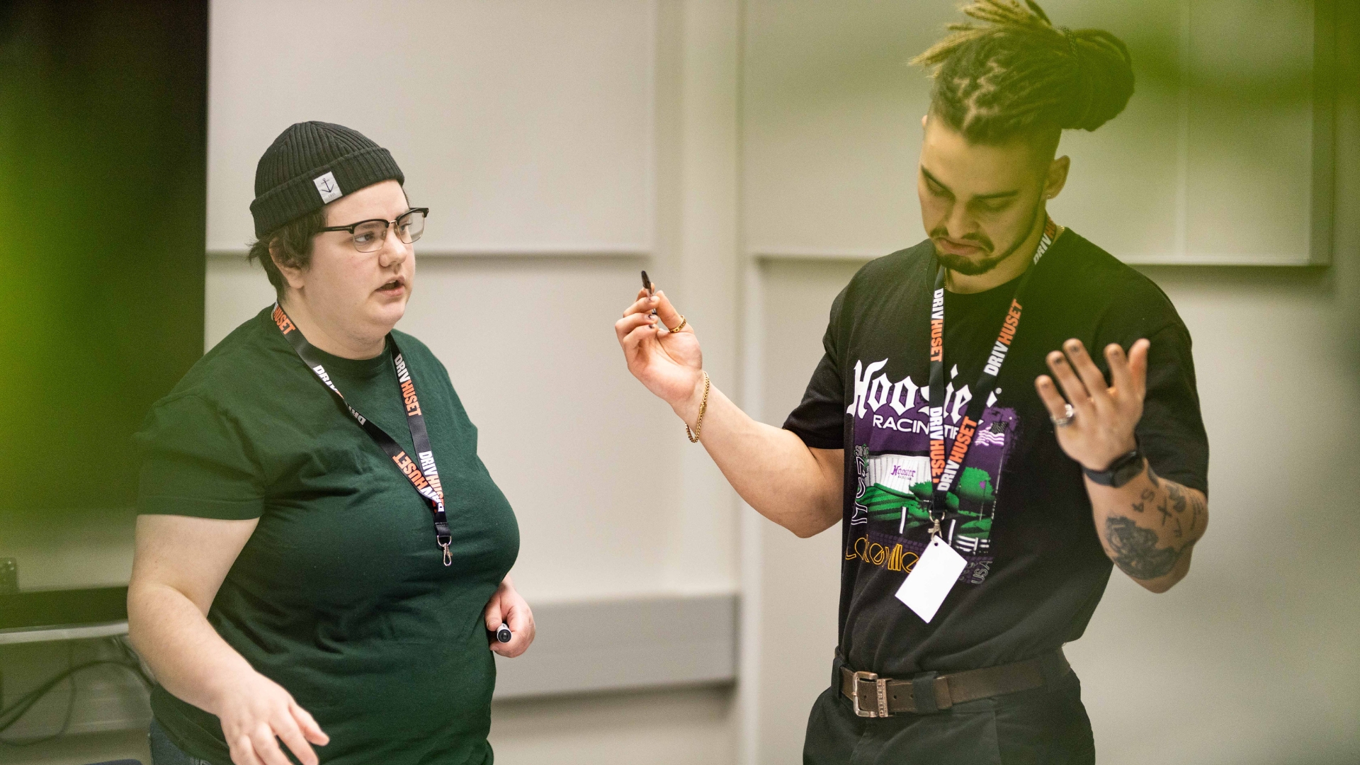 Två studenter i mörka kläder som jobbar tillsamansmed en utmaning