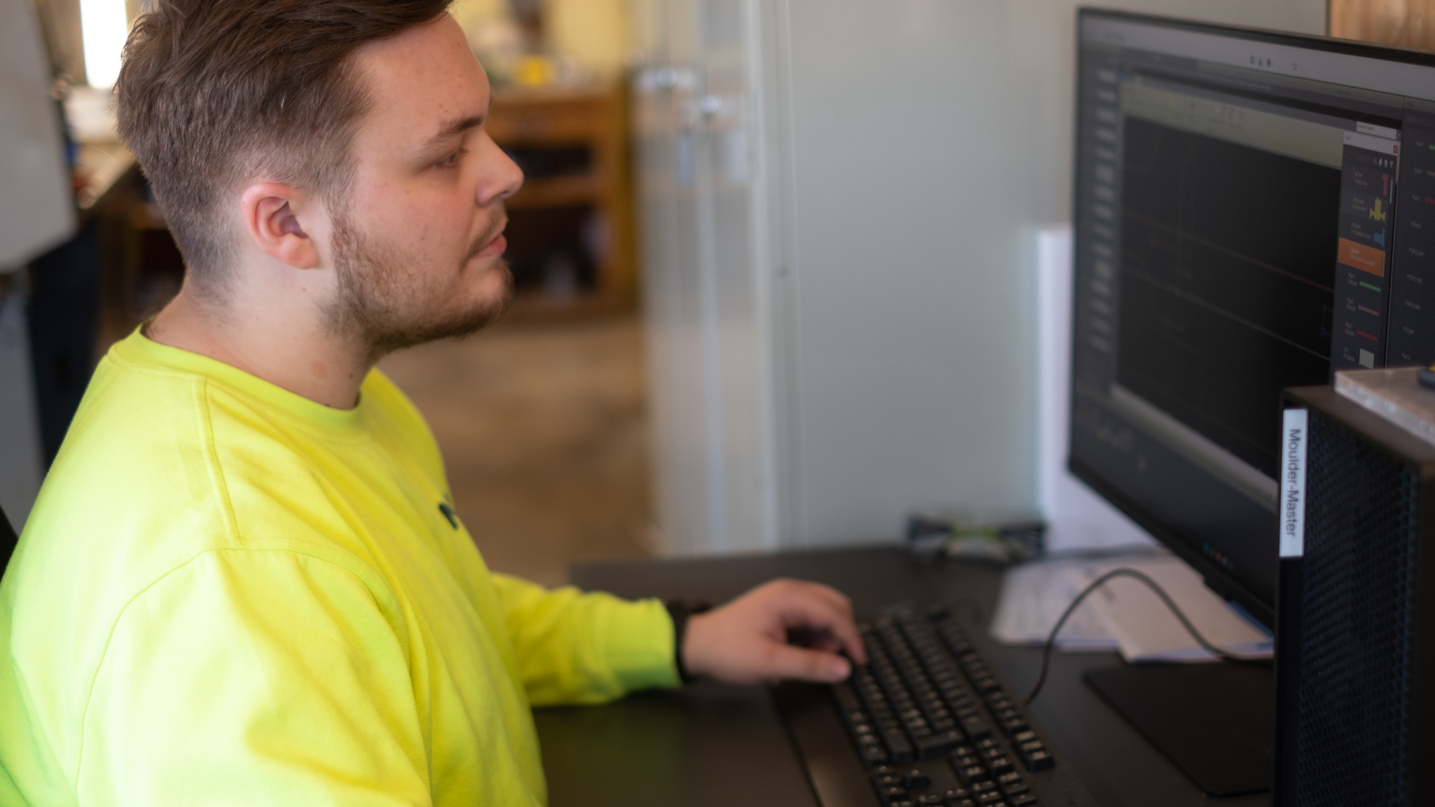 Ansatt Moelven Langmoen foran pc-skjerm. Foto