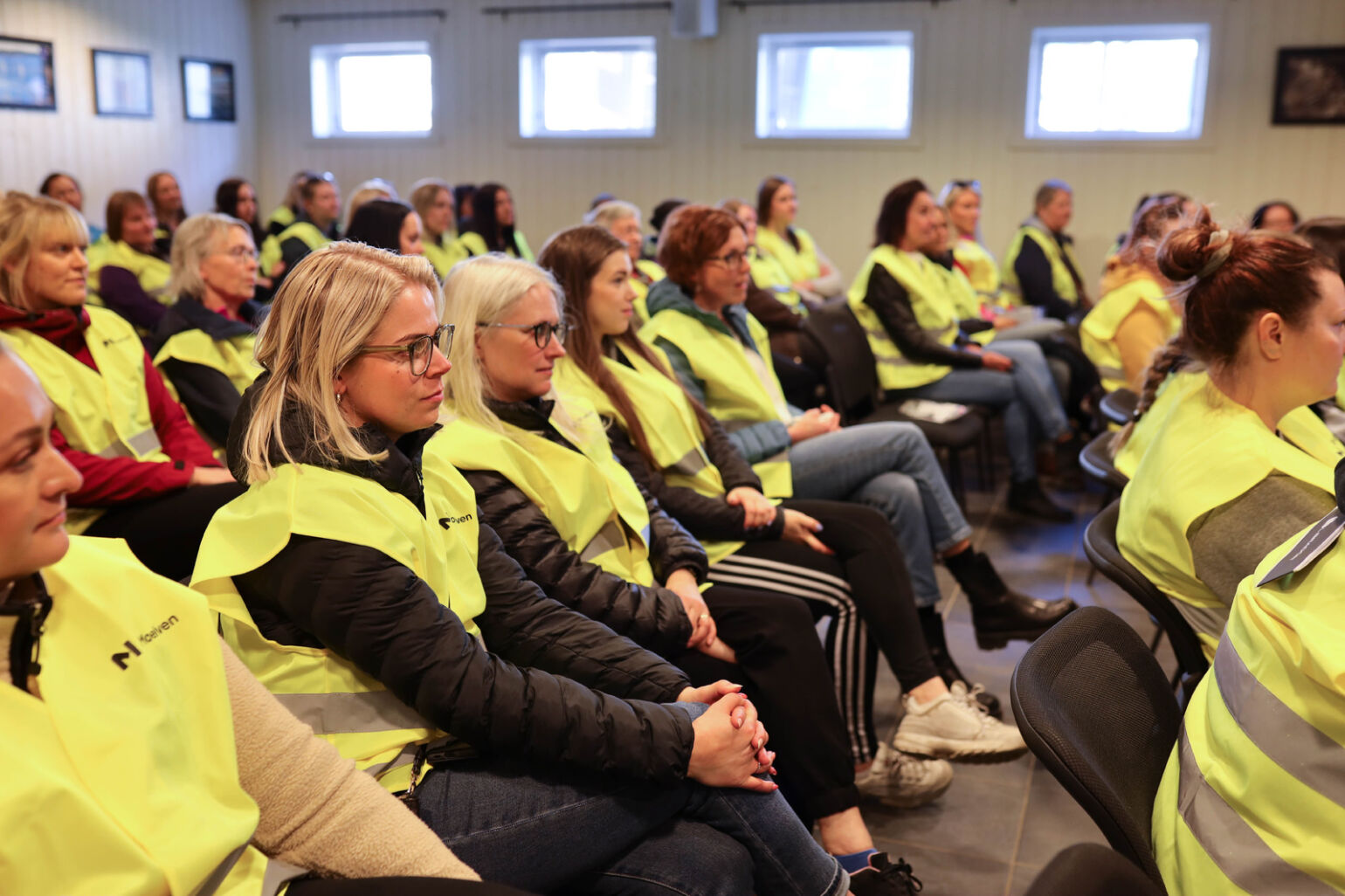 Många tjejer i varselväst i ett publikhav