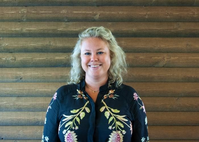 Porträtt av Hedwig Ulander framför vägg i trä