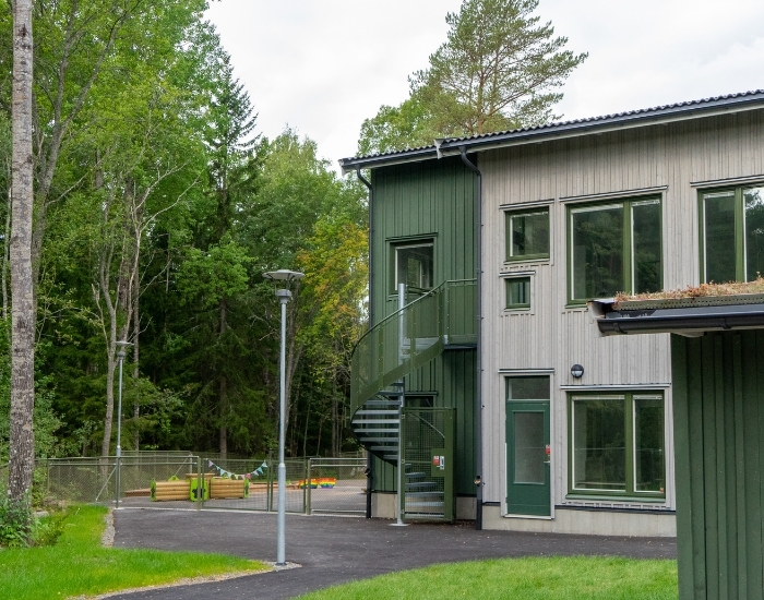 Förskola fotad från  utsidan. Grön och gråmålad fasad.