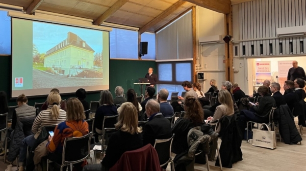 Tilskuere som ser på en skjerm hos Norske Arkitekters Landsforbund