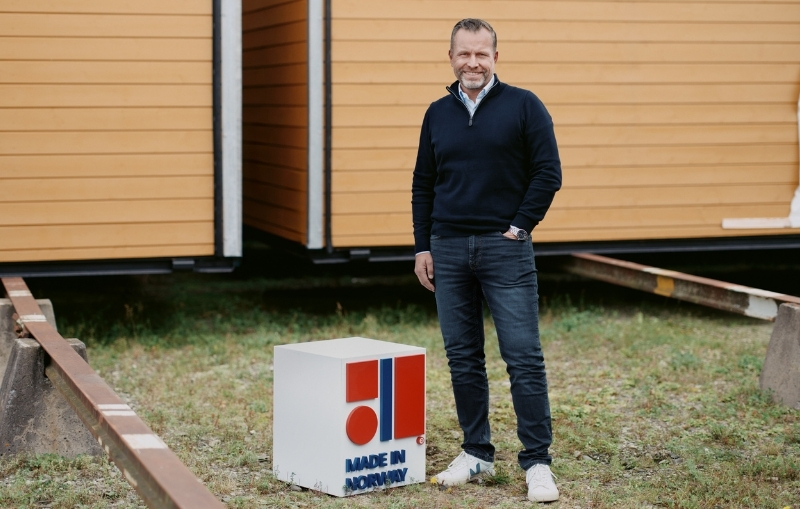 Ansatt fra Moelven Byggmodul står ved siden av en Made in Norway kubeform.