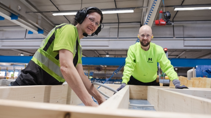 To kolleger i en fabrik, der arbejder sammen.