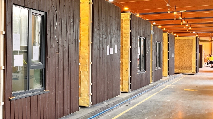 Wooden modules lined up on a factory conveyor belt.