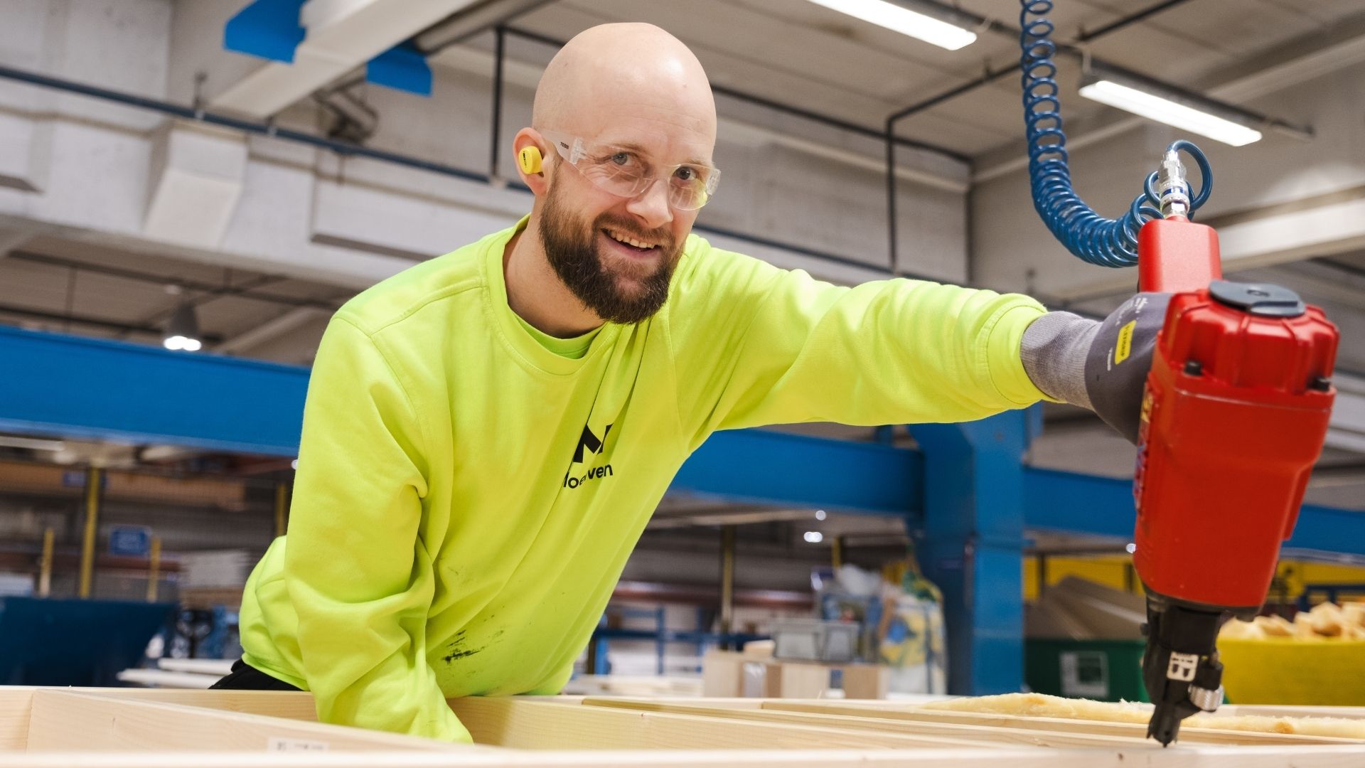 Fabrikkarbeider produserer en byggmodul med spikerpistol.