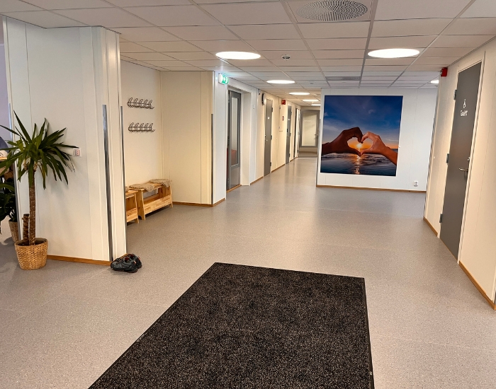 Hvitmalt korridor med dører til sidene