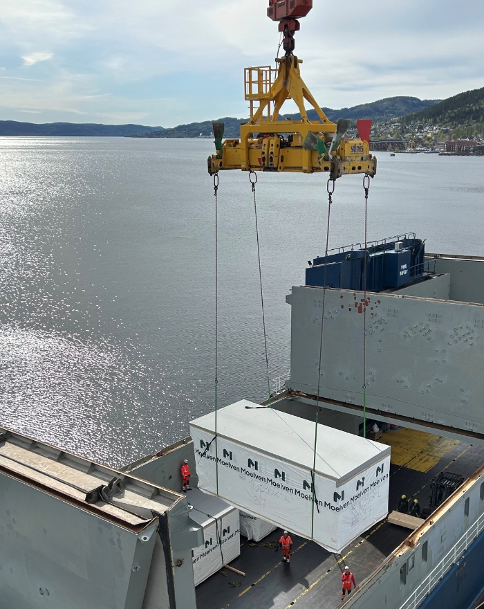 Moelven-profilert modul som heises ombord i et lasteskip.