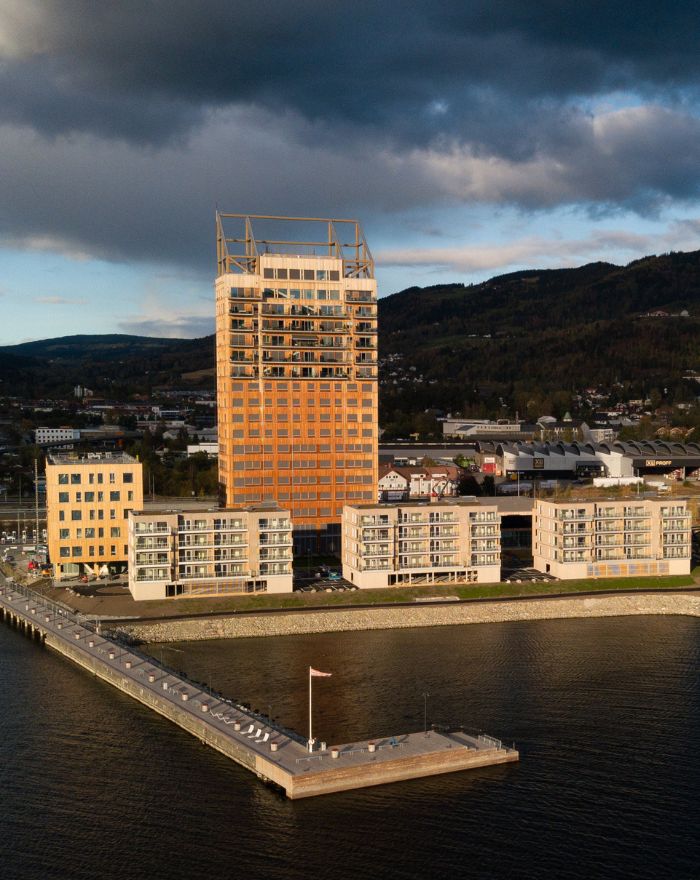 Drönarbild över Mjösknaten med vatten och mjöstårnet i solsken.