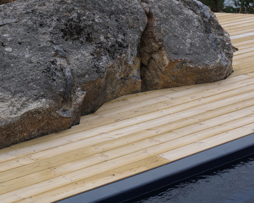 Trall runt en sten, samt hörnet av en pool synes