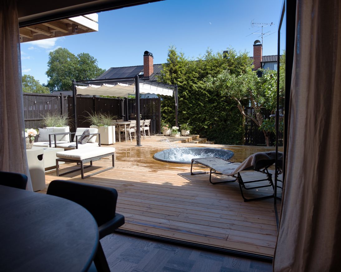 Utsikt över en altan med pergola, liten rund pool och solsäng