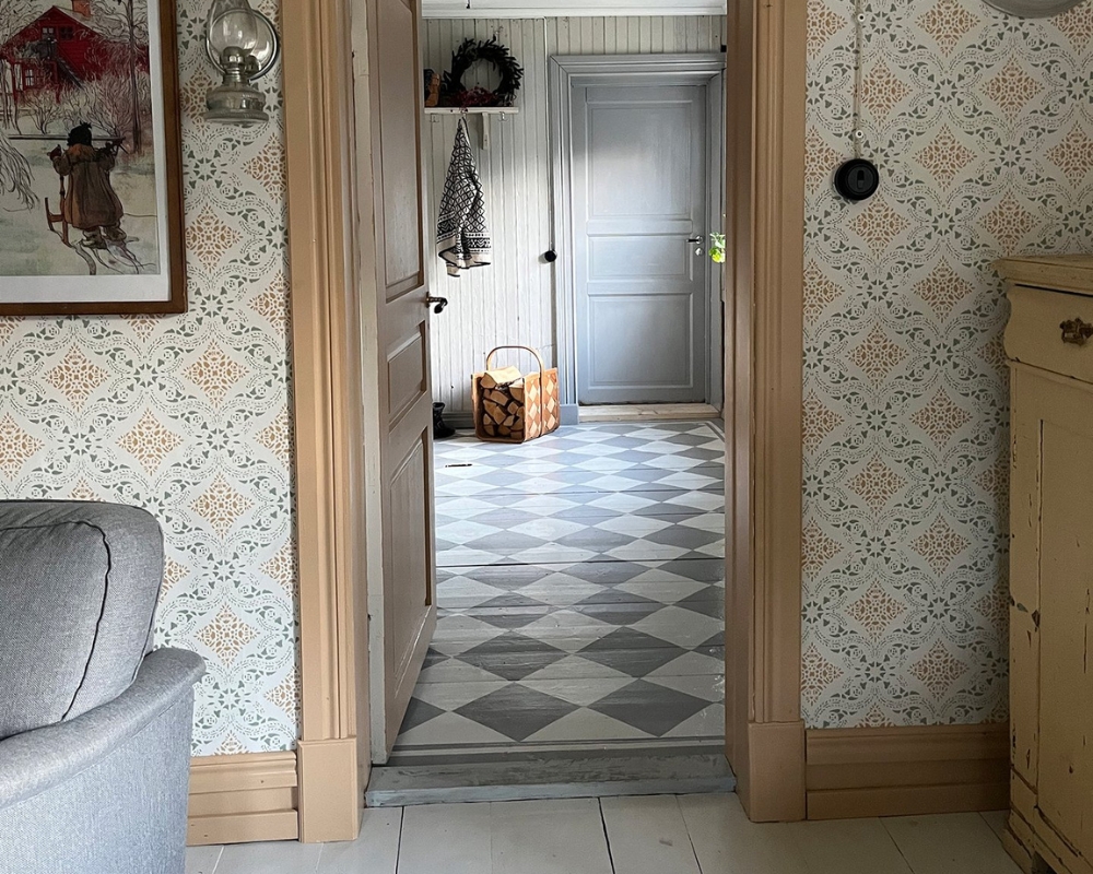 En dörröppning in till en hall med rutigt trägolv