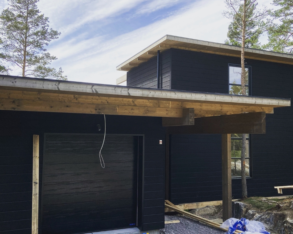 Ett hus med svart limträpanel