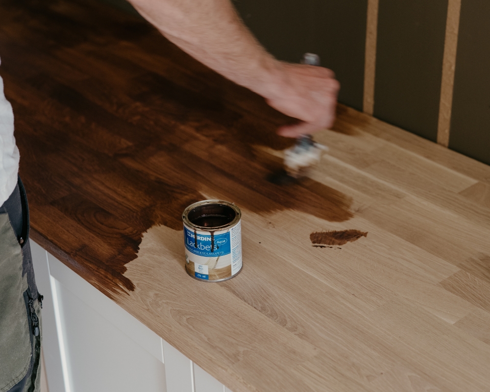 en trähylla blir betsad