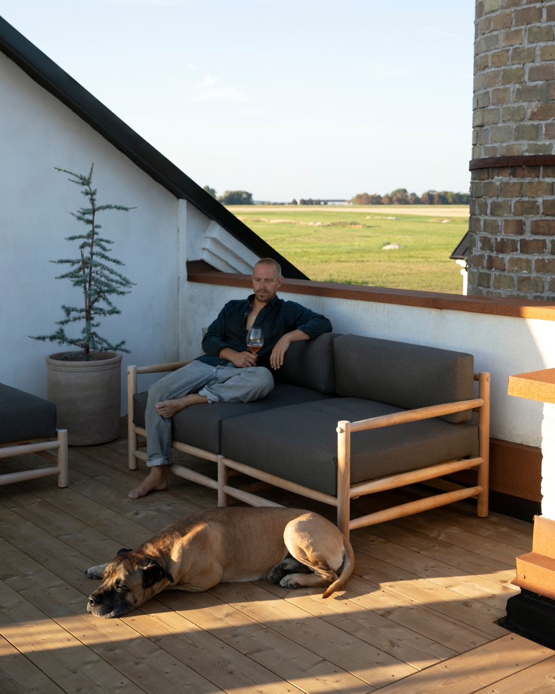 Man och hund chillar på en takterrass av TermoGran