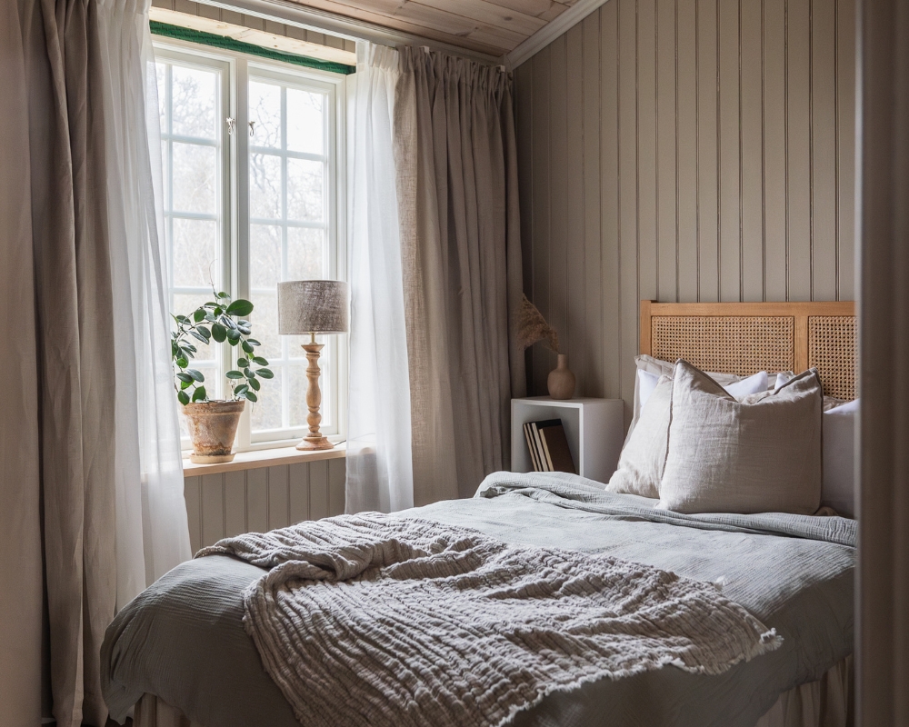 Sovrum med säng, dekorationer och en beige träpanel