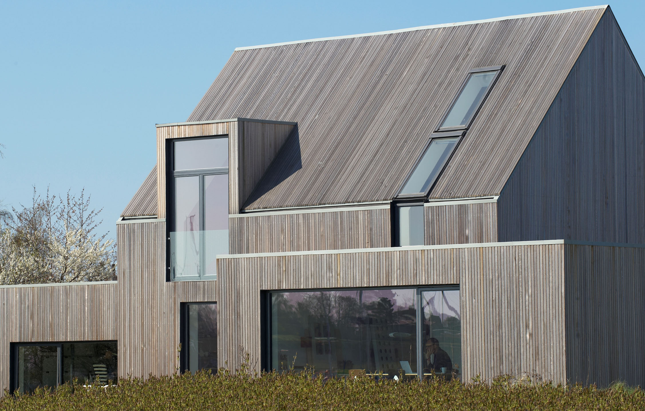 Modernt hus med trätak och fasad av cederträ