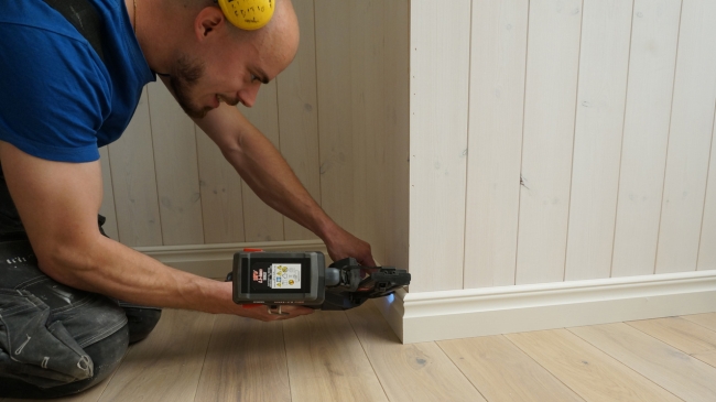 En man som monterar en vit list