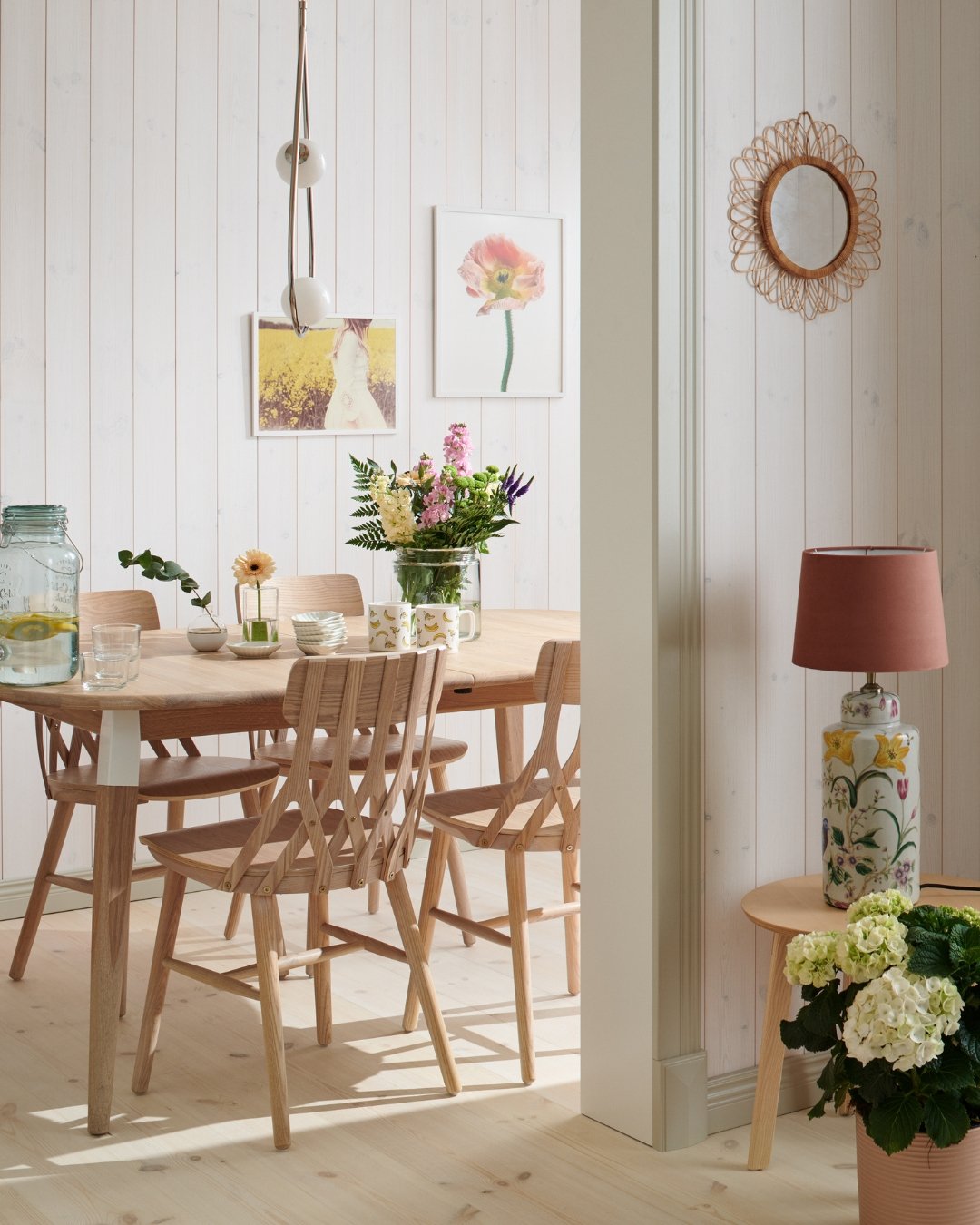 Bord och stolar i trä, en vit panel, beiga lister och trägolv