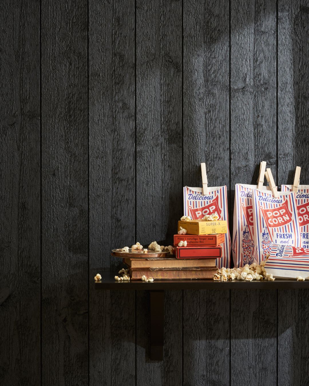 Svart stående innerpanel med hylla med popcornpåsar