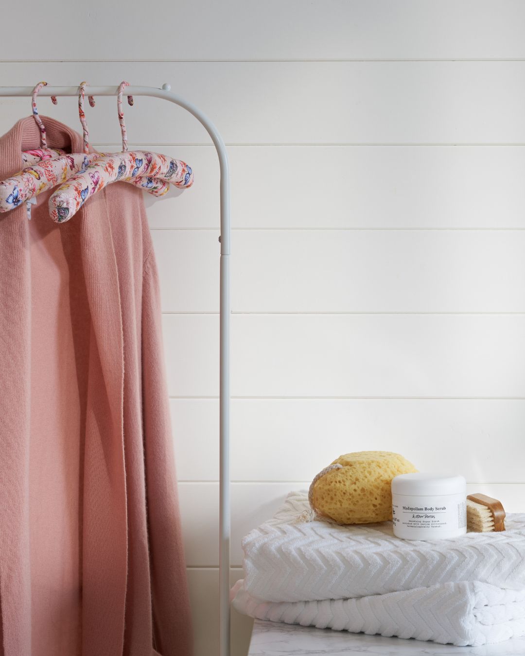Vägg med vit liggande träpanel Trend Fas och en klädställning med rosa morgonrock