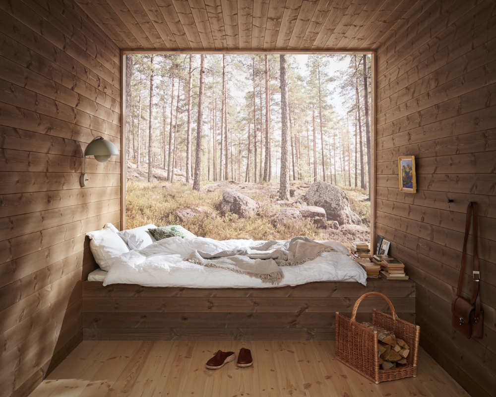 Ett rum med trä från golv till tak, träpanel på väggar och tak, samt trägolv. Utöver det, en inbyggd säng i trä, och ett en glasvägg med utsikt mot skogen
