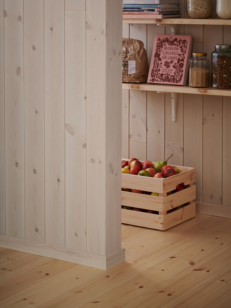 Träpanelen Stilla Morgondis sitter på väggarna. Längst bort ett öppet skafferi.