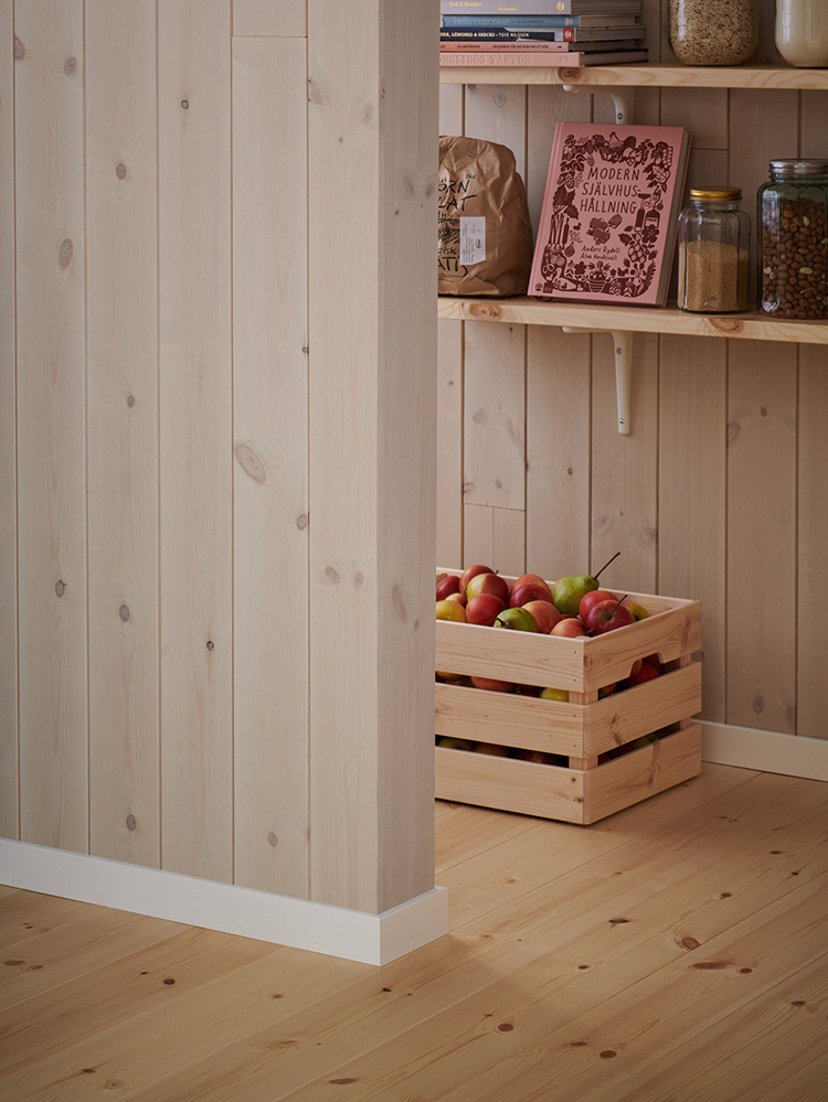 Träpanelen Stilla Morgondis sitter på väggarna. Längst bort ett öppet skafferi.