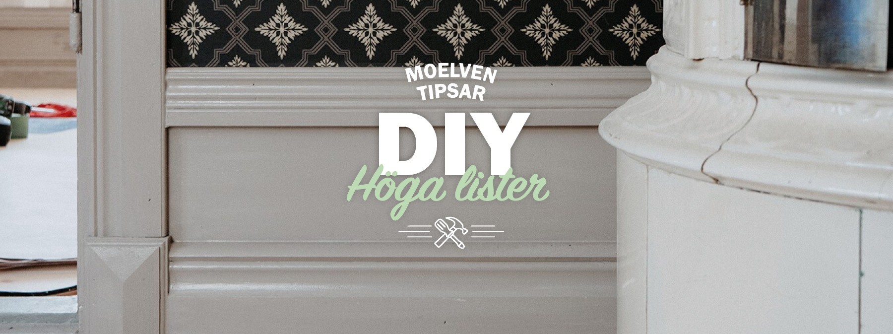 Gråa höga golvlister, med ljust trägolv, samt en vit kakelugn