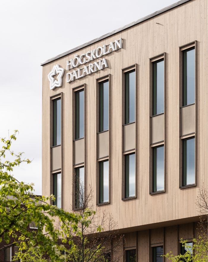 Fasad av ThermoWood BT Pigment Silver med fönster som ramas in av ribbor.