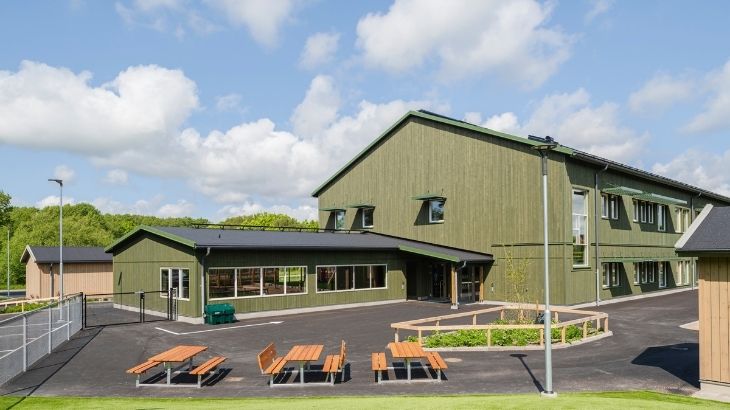 Tre picknickbord framför Limabacka förskola med KulörOlja Grön