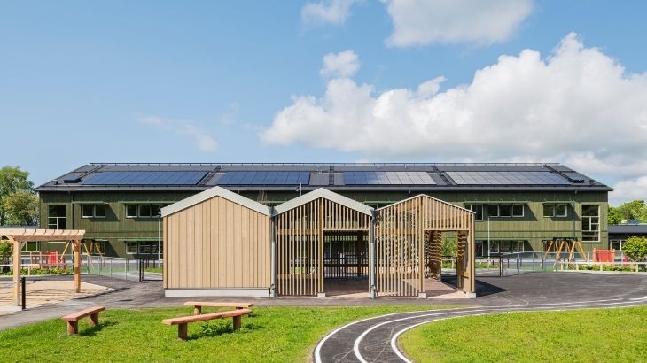 Komplementbyggnad med utomhusklassrum i Kärnfuru KulörOlja Silver framför Limabacka förskola i Kärnfuru KulörOlja Grön