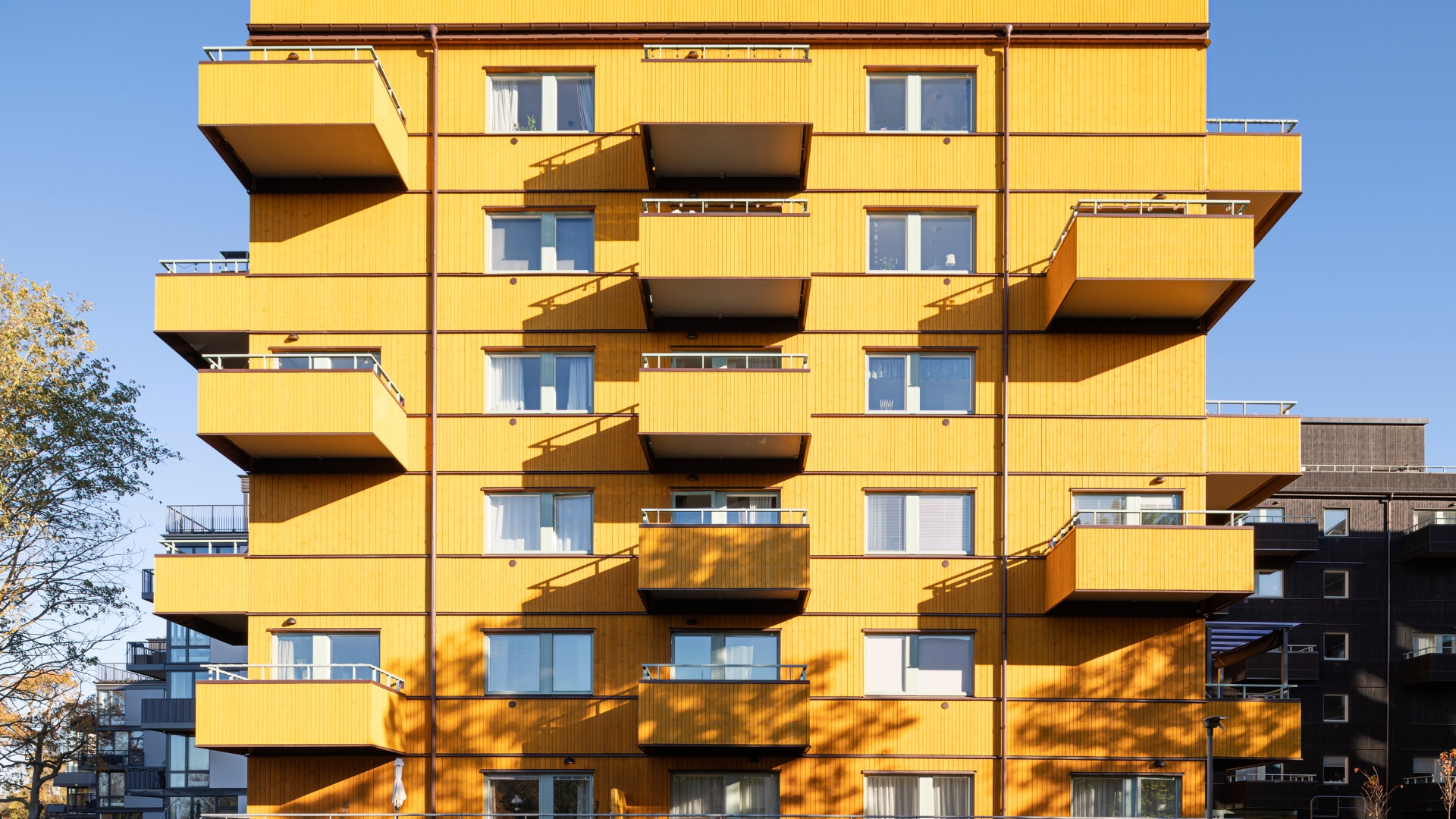 Flerbostadshus med fasad av ThermoWood BT PIgment Gul.