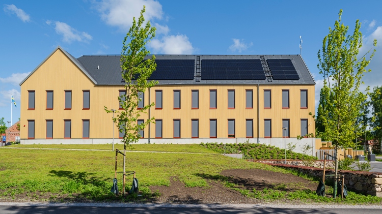 Träd framför Östra Göinge kommunhus med fasad av ThermoWood BT Pigment Ockragul