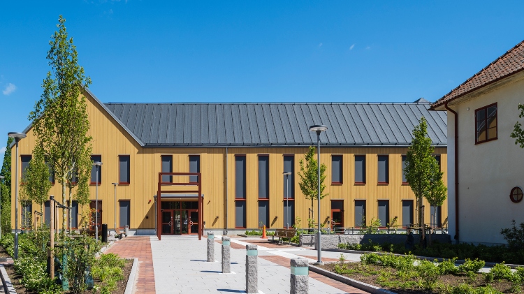 Entré på Östra Göinge kommunhus med fasad av ThermoWood BT Pigment Ockragul