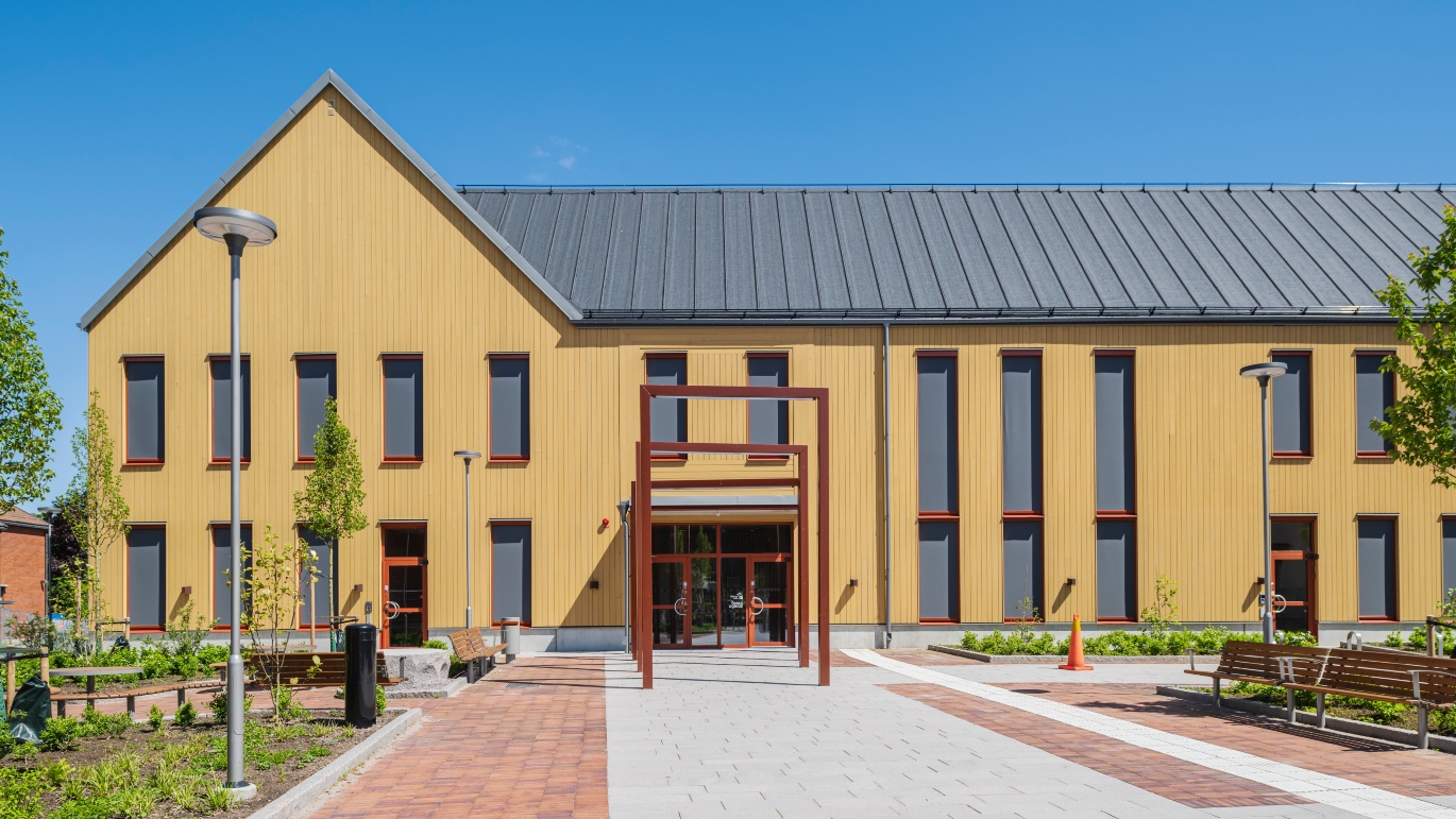 Entré av Östra Göinge kommunhus med ThermoWood BT Pigment Ockragul som fasad