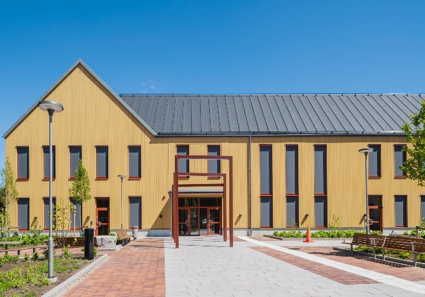 Entré av Östra Göinge kommunhus med ThermoWood BT Pigment Ockragul som fasad