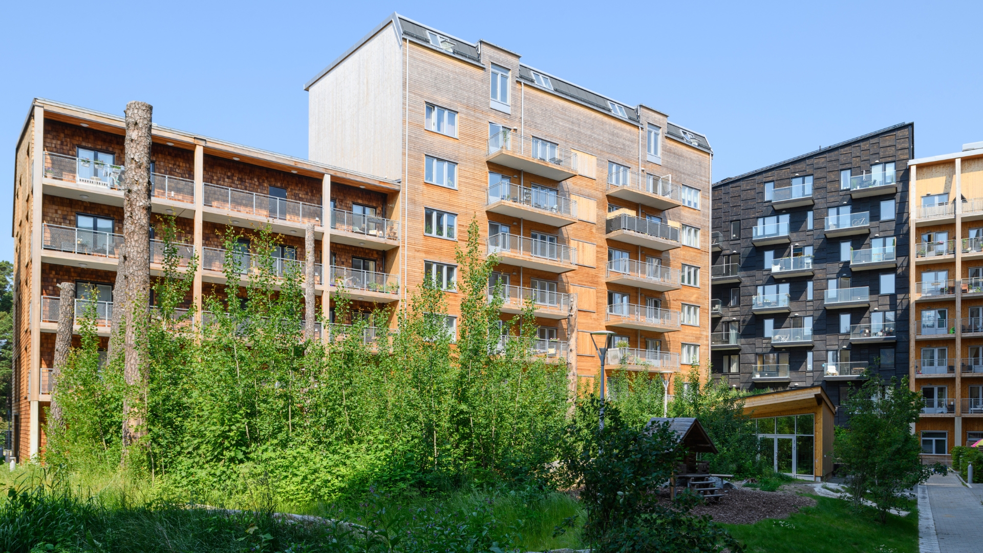 Flerbostadshus med fasader av Cederträspån och naturlig och svartpigmenterad panel av ThermoWood.