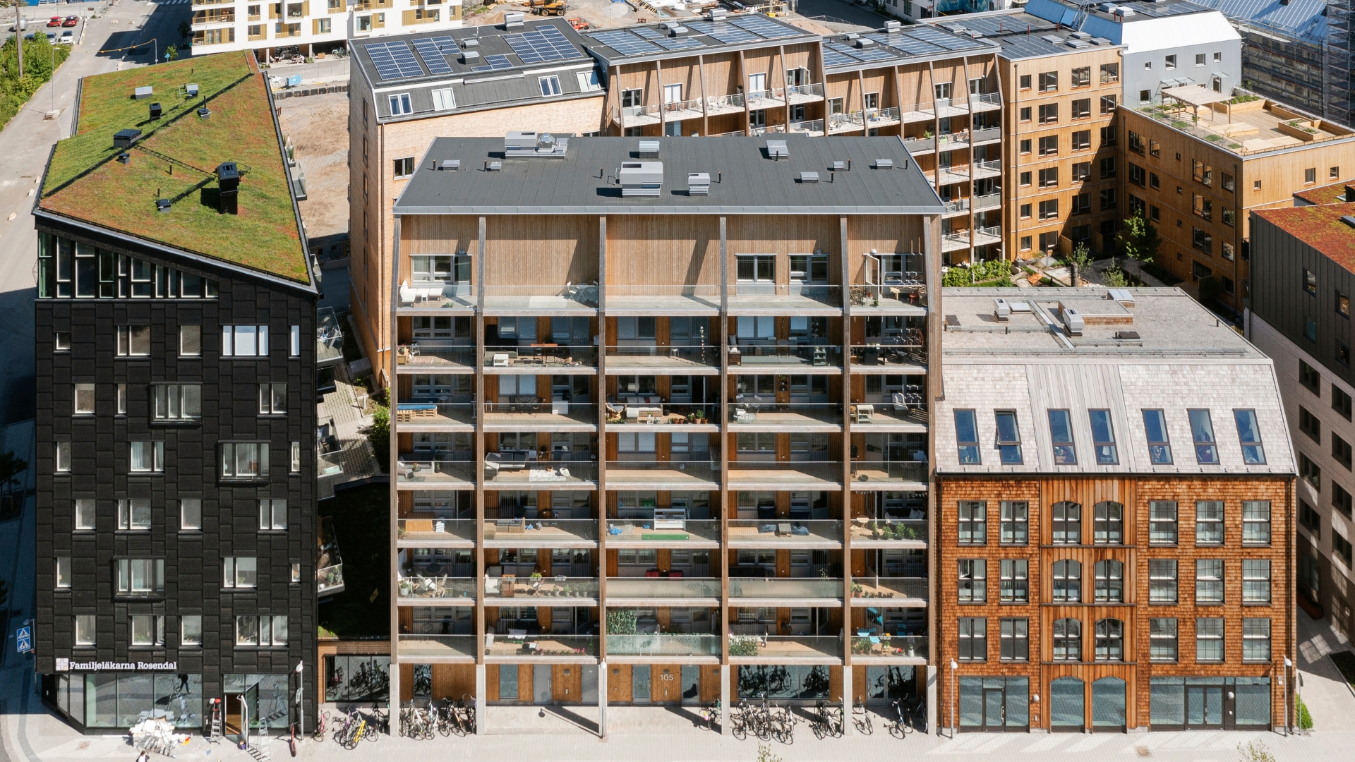 Flerbostadshus med fasad av Svartpigmenterad ThermoWood och panel och spån i Cederträ.