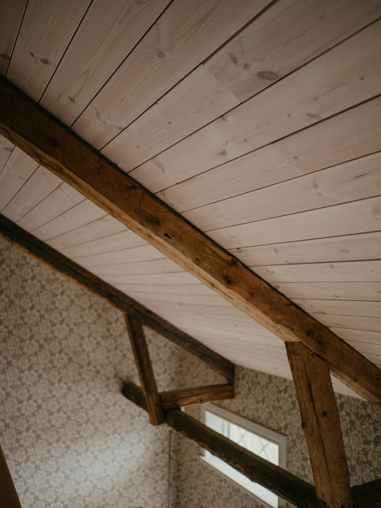 Träpanel i snedtak med synliga bjälklag