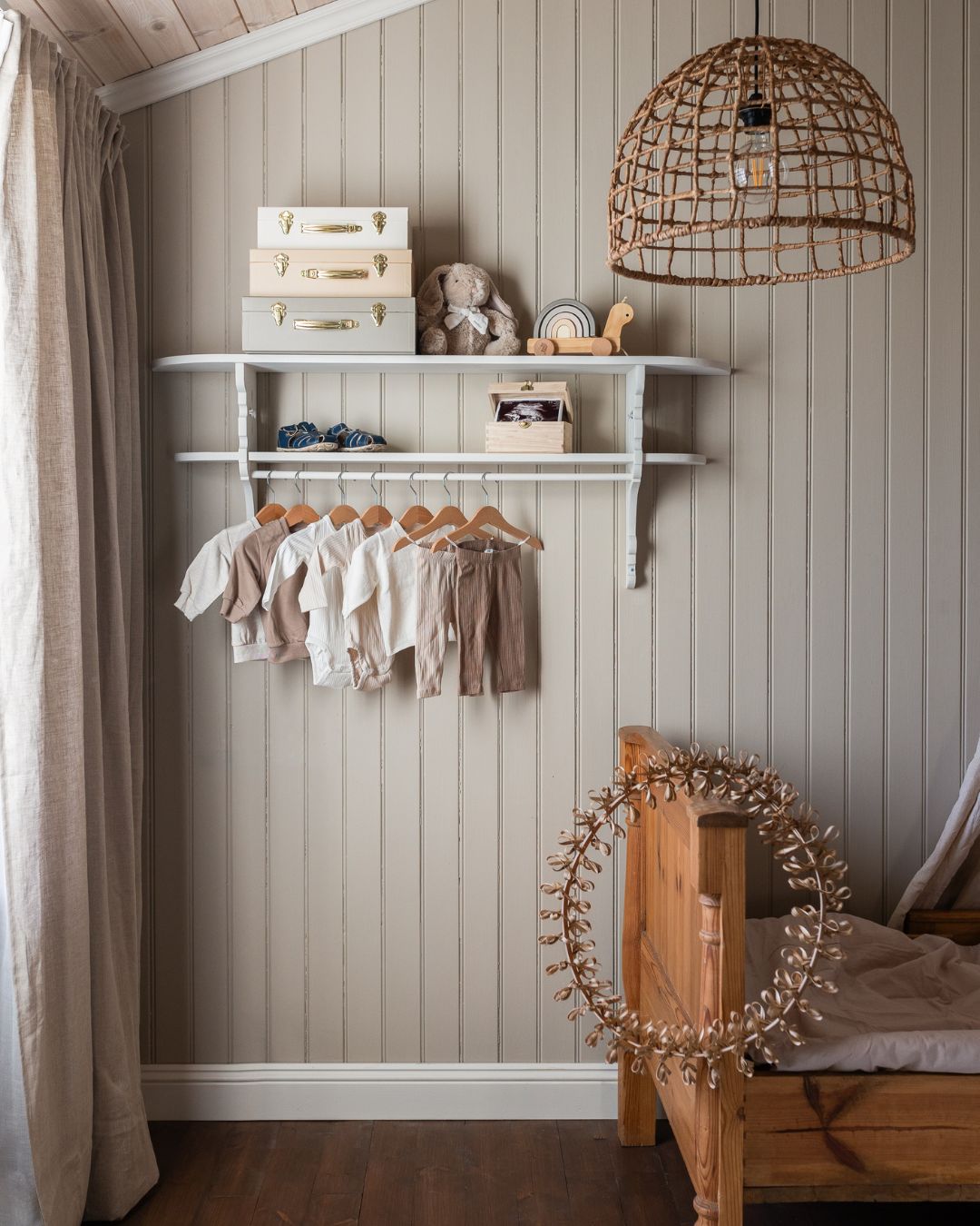 Barnerom med beige perlestaffpanel, skuteseng, jute lampe og hylle i hvitmalt furu med barneleker på.