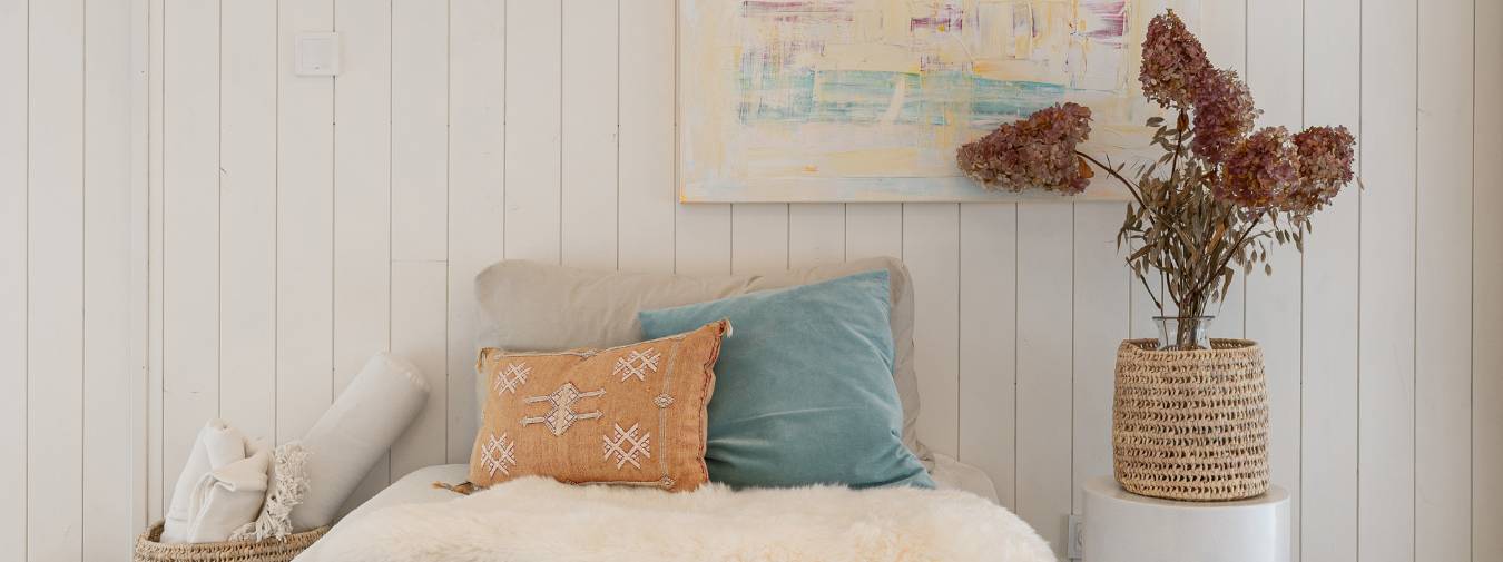 Ferdigmalt panel sprekkpanel i fargen hvit på soverom med hvite og turkise interiørdetaljer