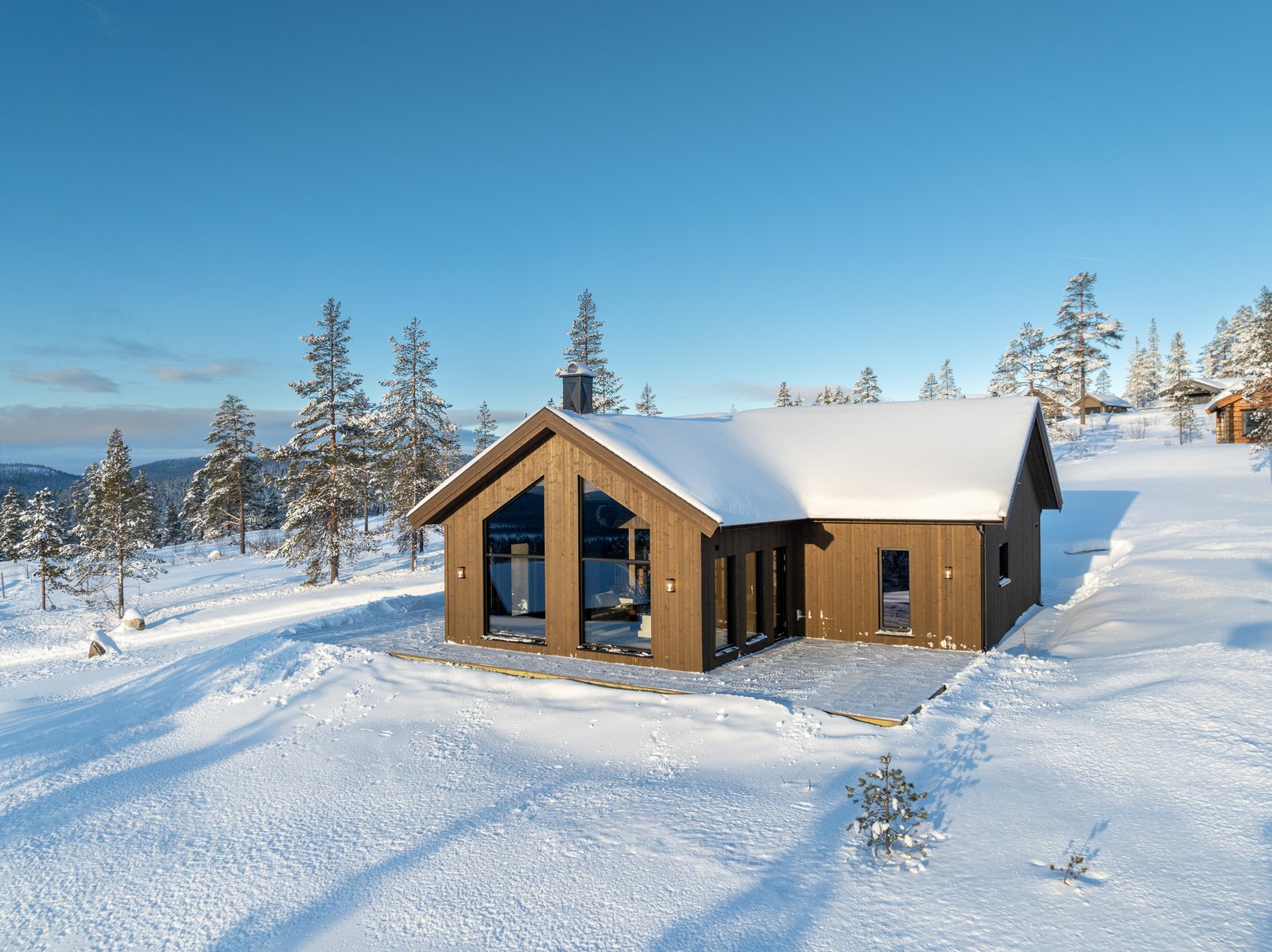 Hytte i snø med blå himmel