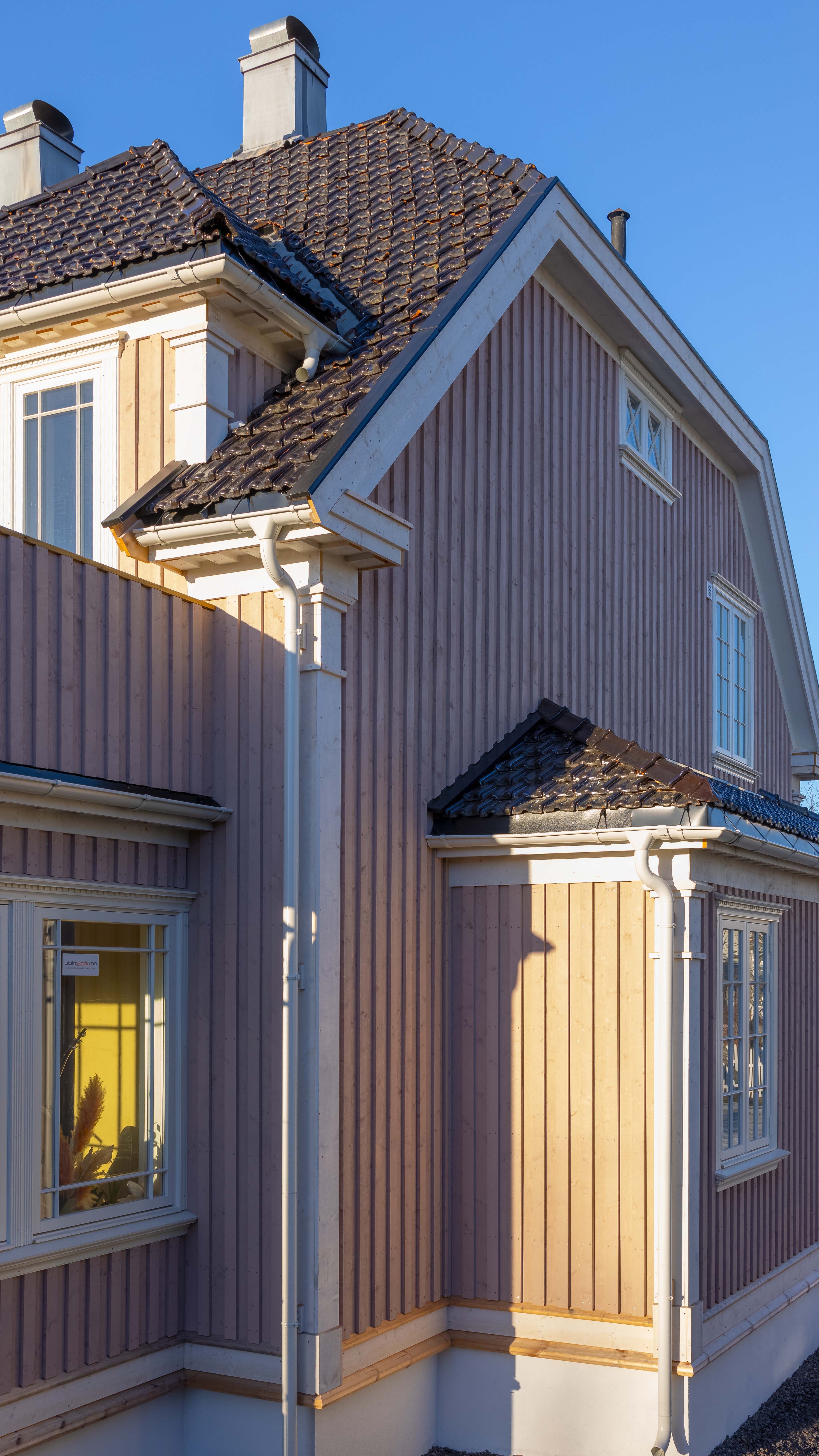 Eldre hus med ny kledning malt rosa.