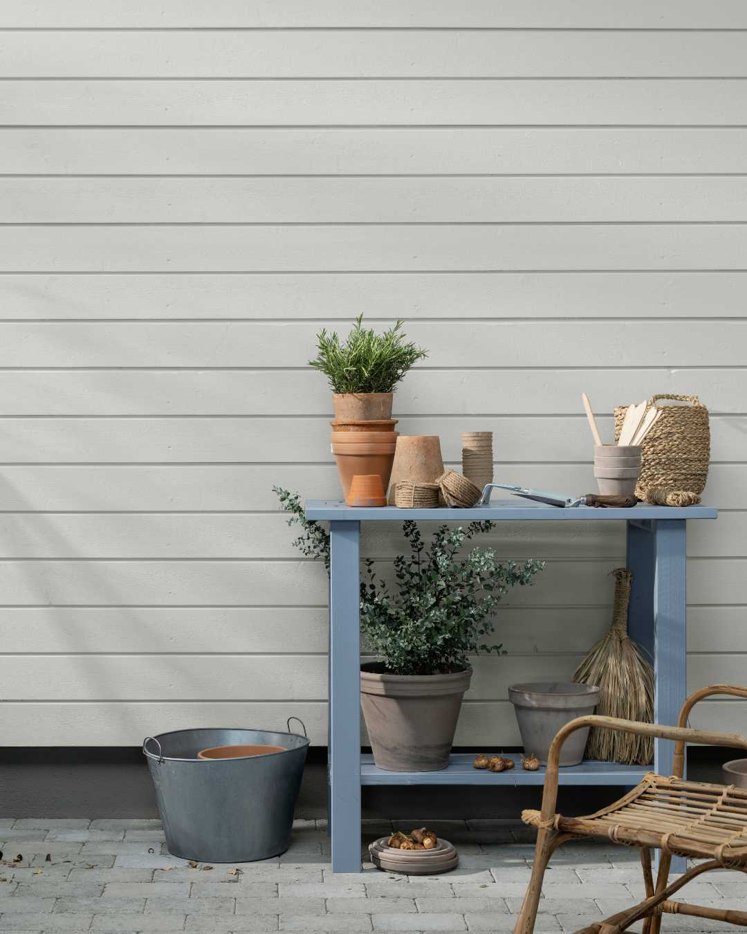 Husfasade med liggende trekledning med hagebord forann.