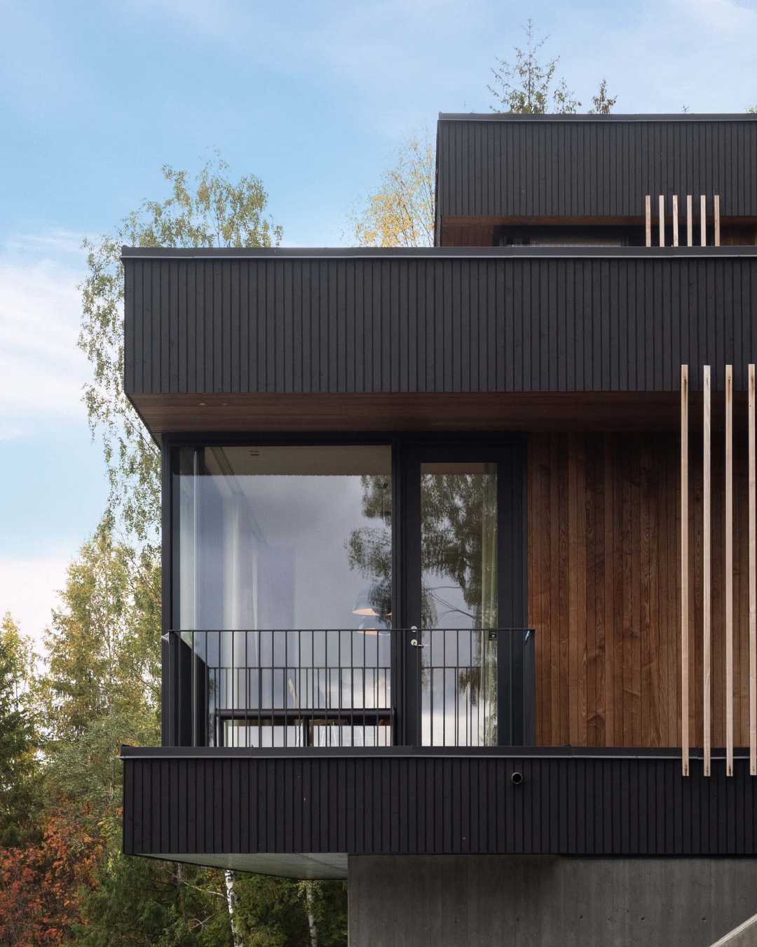 Moderne hus med stående trekledning og store vinduer