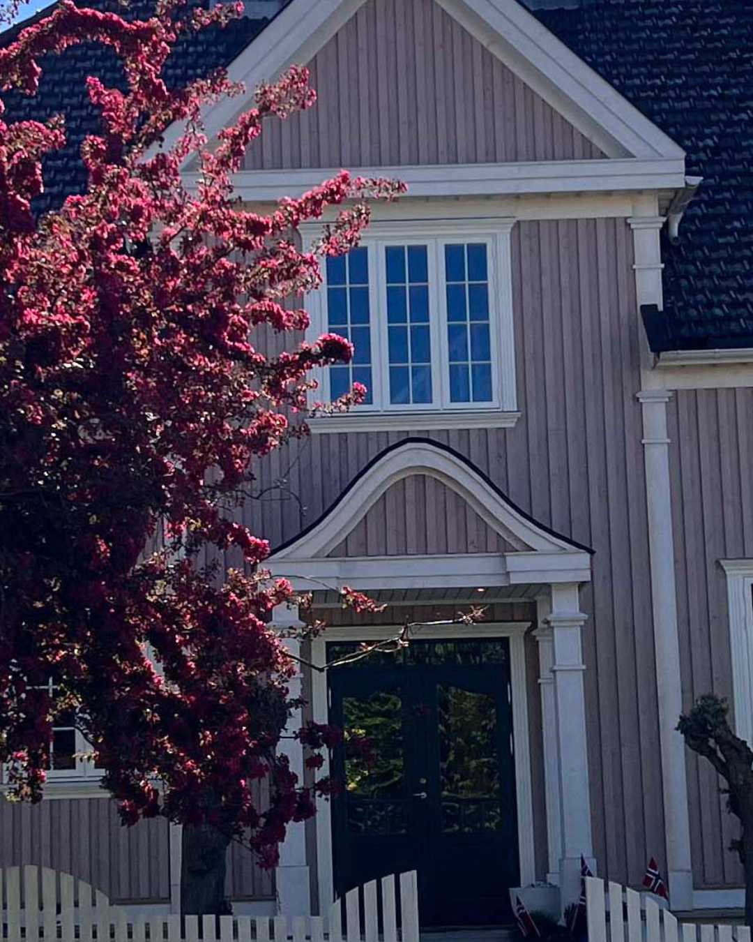 Rosa hus med trefasade og hvite omramminger