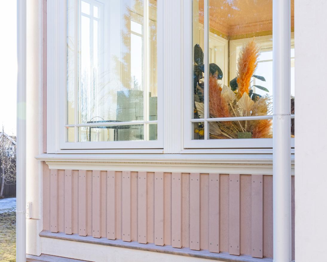 Nærbilde av Heftig PRO rektangulær kledning i rosa under et stort vindu med hvite vinduskarmer og klassisk vinduslist
