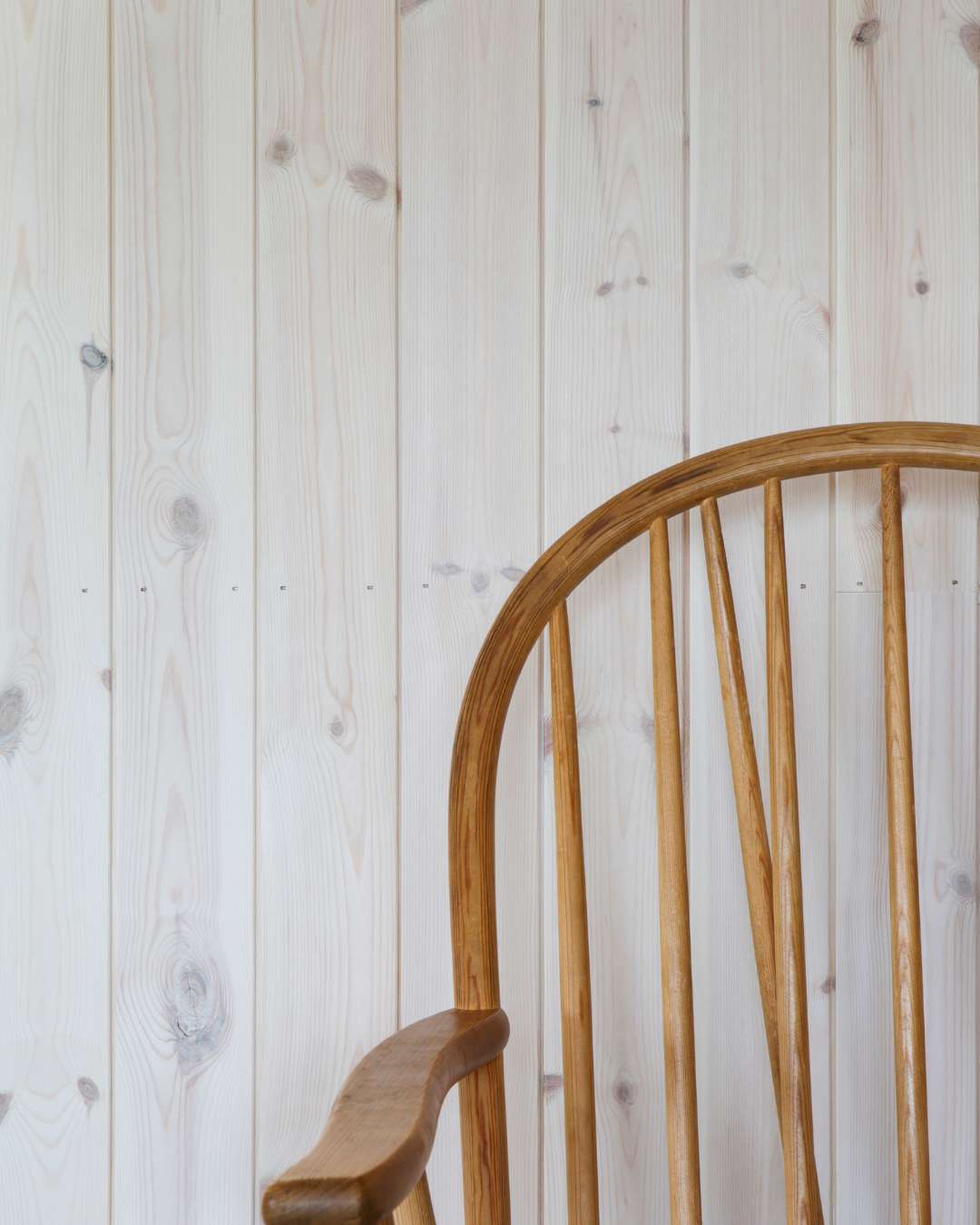 Trepanel Sprekk i hvitlasert med en trestol inntil